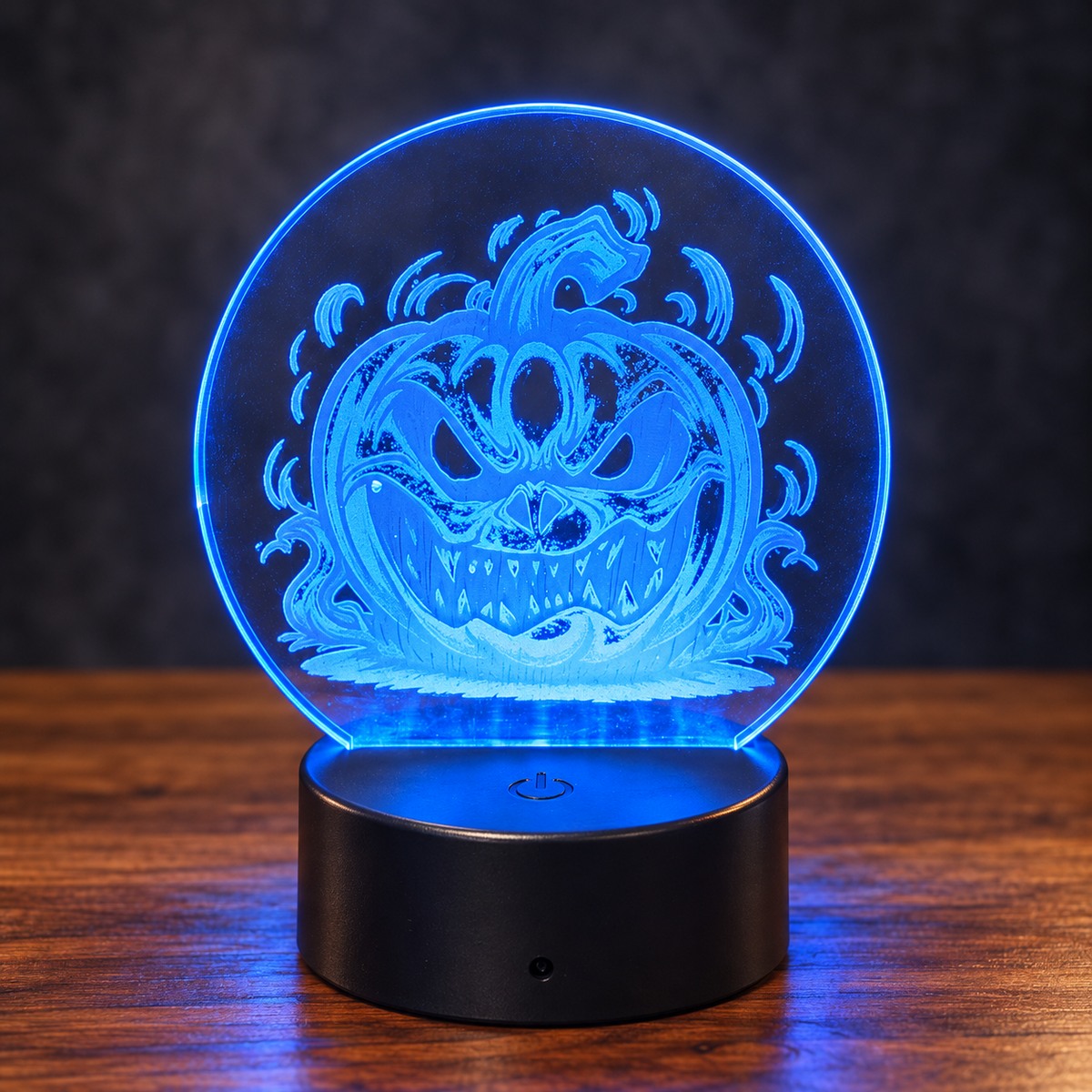 Jack-o'-lantern acrylic LED light illuminated blue on a black base